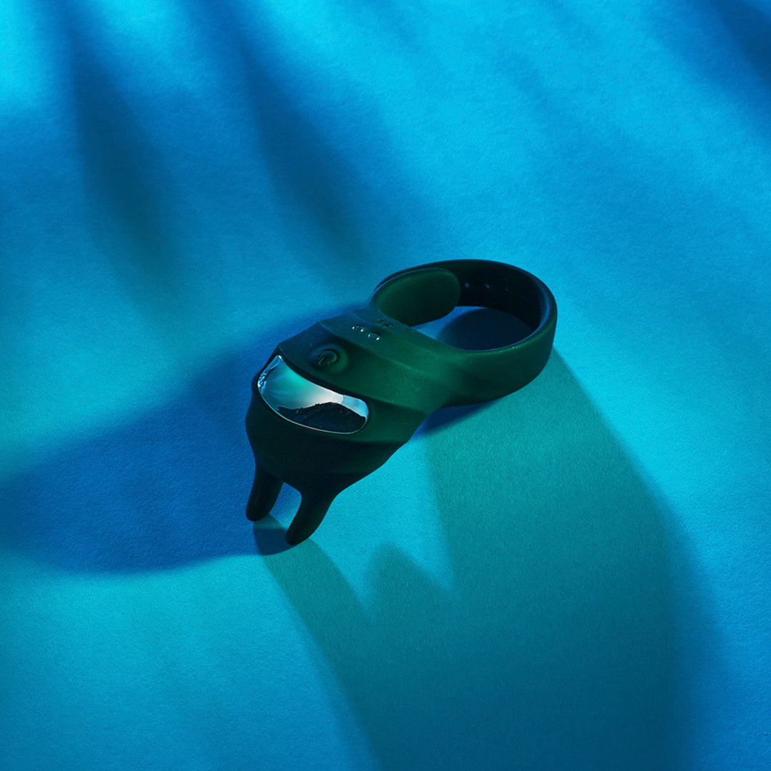 A black Dark Knight, vibrating ring Bedroom Toy by Euforia on a blue background.