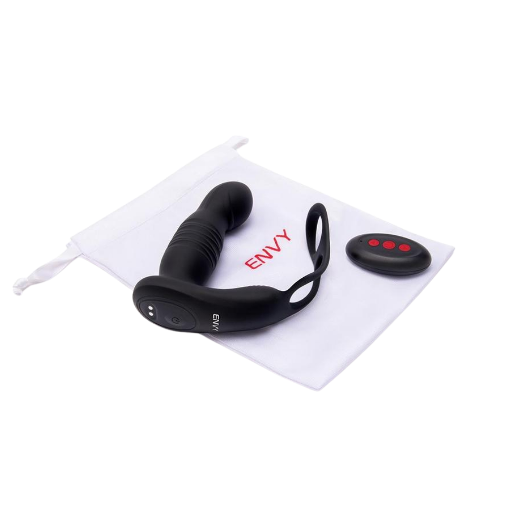 A black Thruster vibrating plug with an attached stamina ring next to the remote, sitting on the white bag.