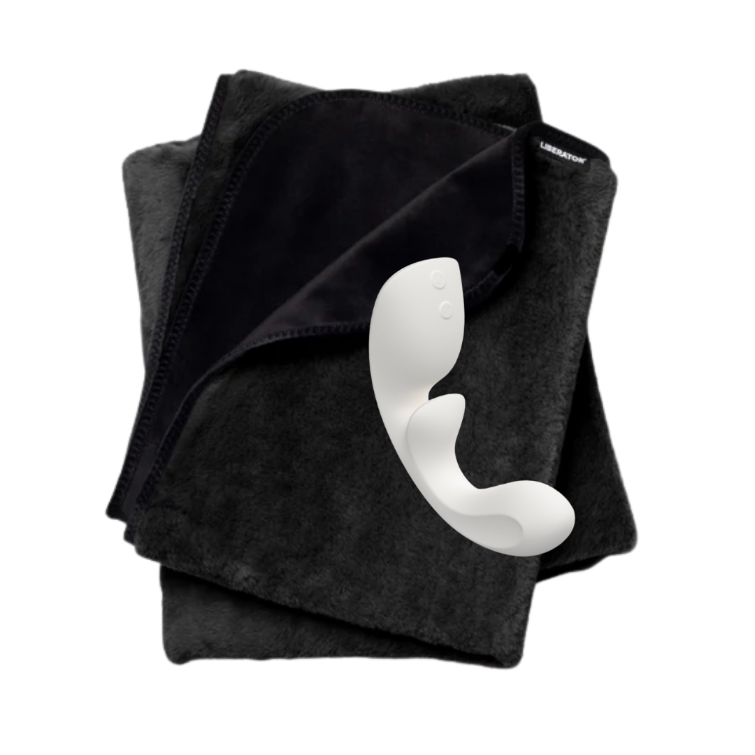 Folded black fascinator waterproof blanket with a white curved Flow g-spot toy on a white background