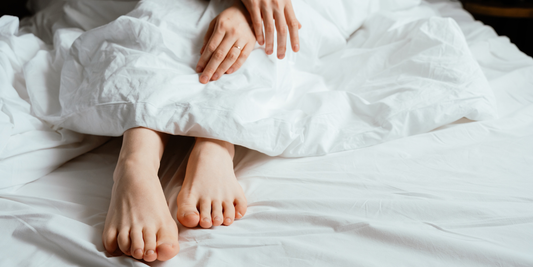 Feet in ruffled bedsheets