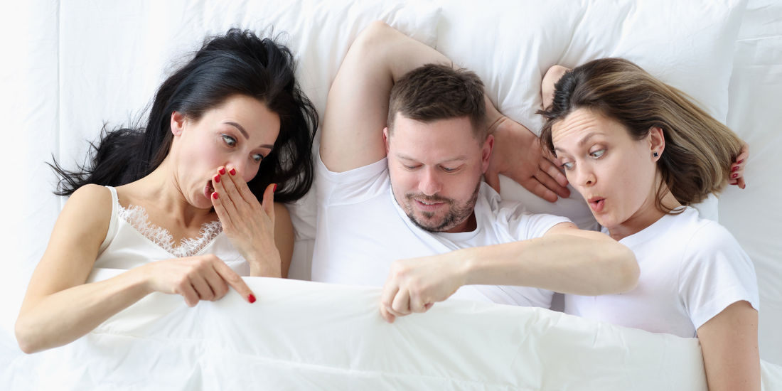 three people laying in bed