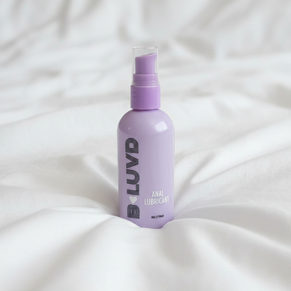 B-luvd anal Lubricant on a bed with ruffled sheets