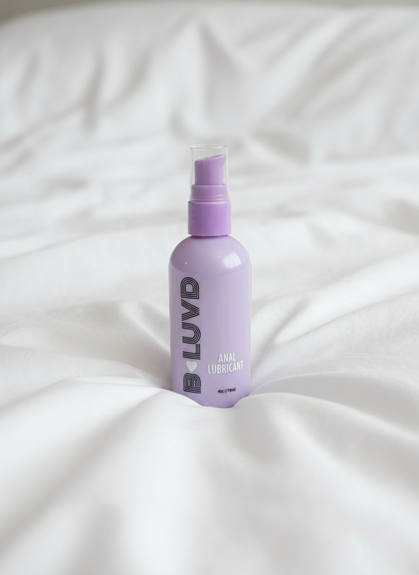 B-luvd anal Lubricant on a bed with ruffled sheets