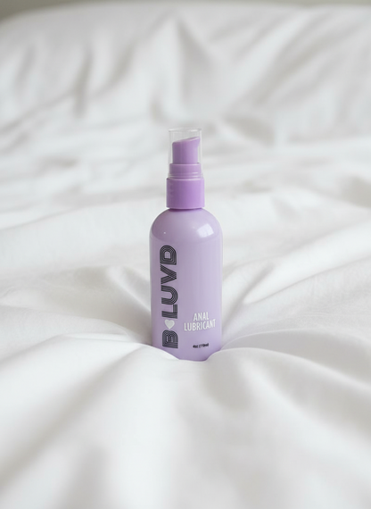 B-luvd anal Lubricant on a bed with ruffled sheets