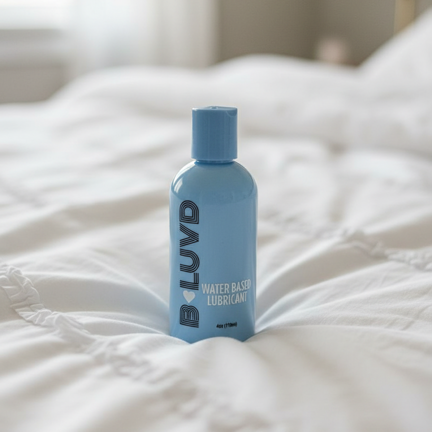 B-Luvd Water Based Lubricant blue bottle on a bed 