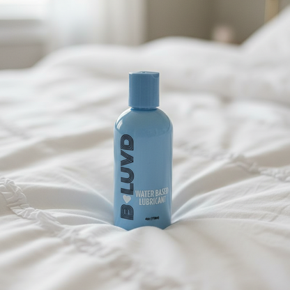 B-Luvd Water Based Lubricant blue bottle on a bed 