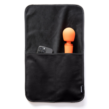 A black bed caddy by Fascinator holding a toy and a phone.