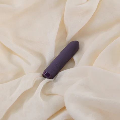 A purple Classic Bullet by Je Joue on a white sheet.
