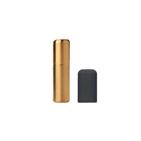 A 24 gold Crave bullet sitting next to the black, silicone cap.