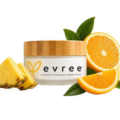 A white jar of Edible Massage Cream by Evree sitting beside oranges and pieces of pineapple.