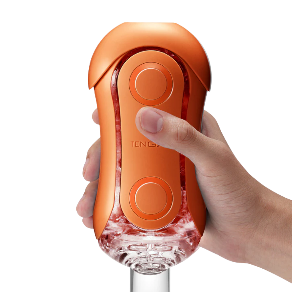 Hand holding an orange and clear male sleeve on a white background