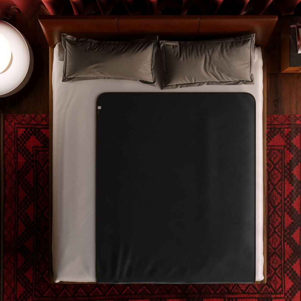 The back barrier of a Fascinator Luxe Splashproof Fur blanket laying on a bed.