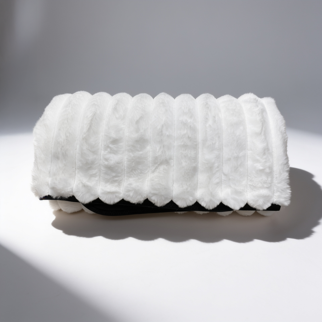 A white Fascinator Luxe Splashproof Fur blanket rolled up against a white background.