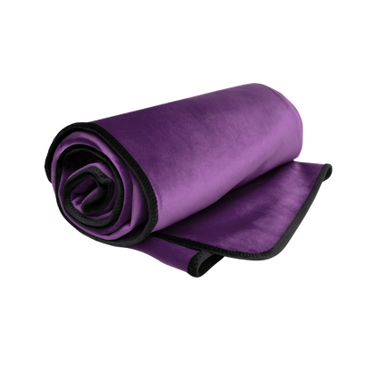 An aubergine Fascinator Splashproof Throws, Bedroom Furniture by Liberator rolled up.