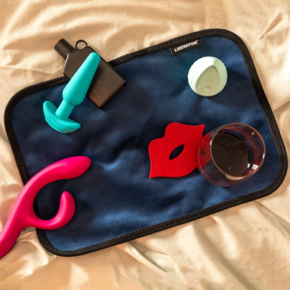 A toy pad size blue Fascinator Splashproof Throws, Bedroom Furniture by Liberator sitting on a bed with toys on it.