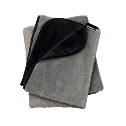 A grey faux fur Fascinator Splashproof Throws, Bedroom Furniture by Liberator folded up.