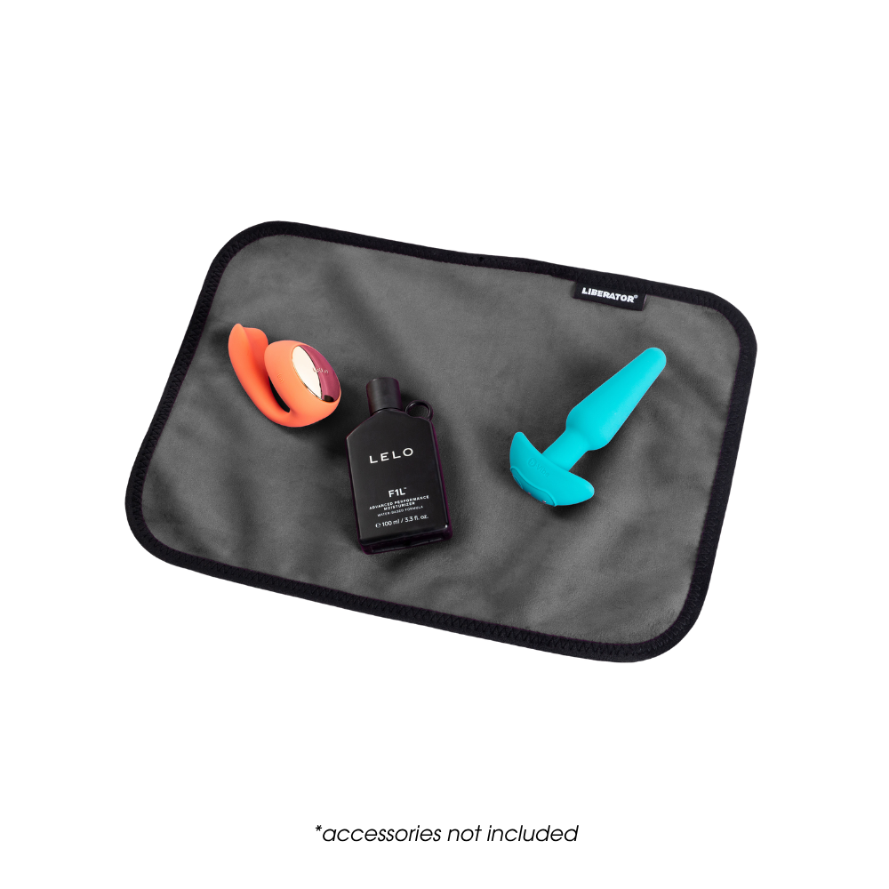 A toy pad size grey Fascinator Splashproof Throws, Bedroom Furniture by Liberator sitting on a bed with toys on it.