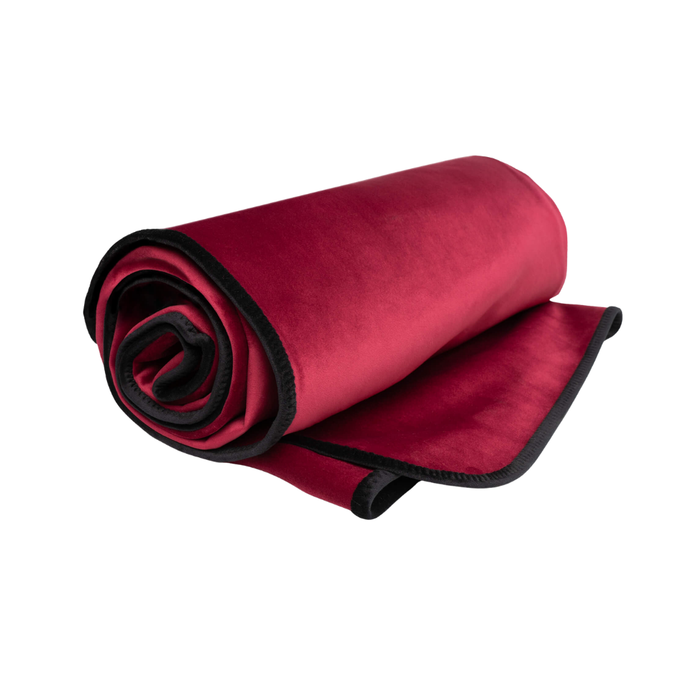 A merlot Fascinator Splashproof Throws, Bedroom Furniture by Liberator rolled up.