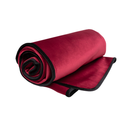 A merlot Fascinator Splashproof Throws, Bedroom Furniture by Liberator rolled up.