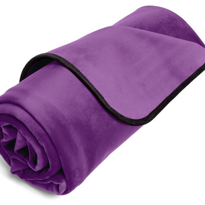 A purple indigo Fascinator Splashproof Throws, Bedroom Furniture by Liberator rolled up against a white background.