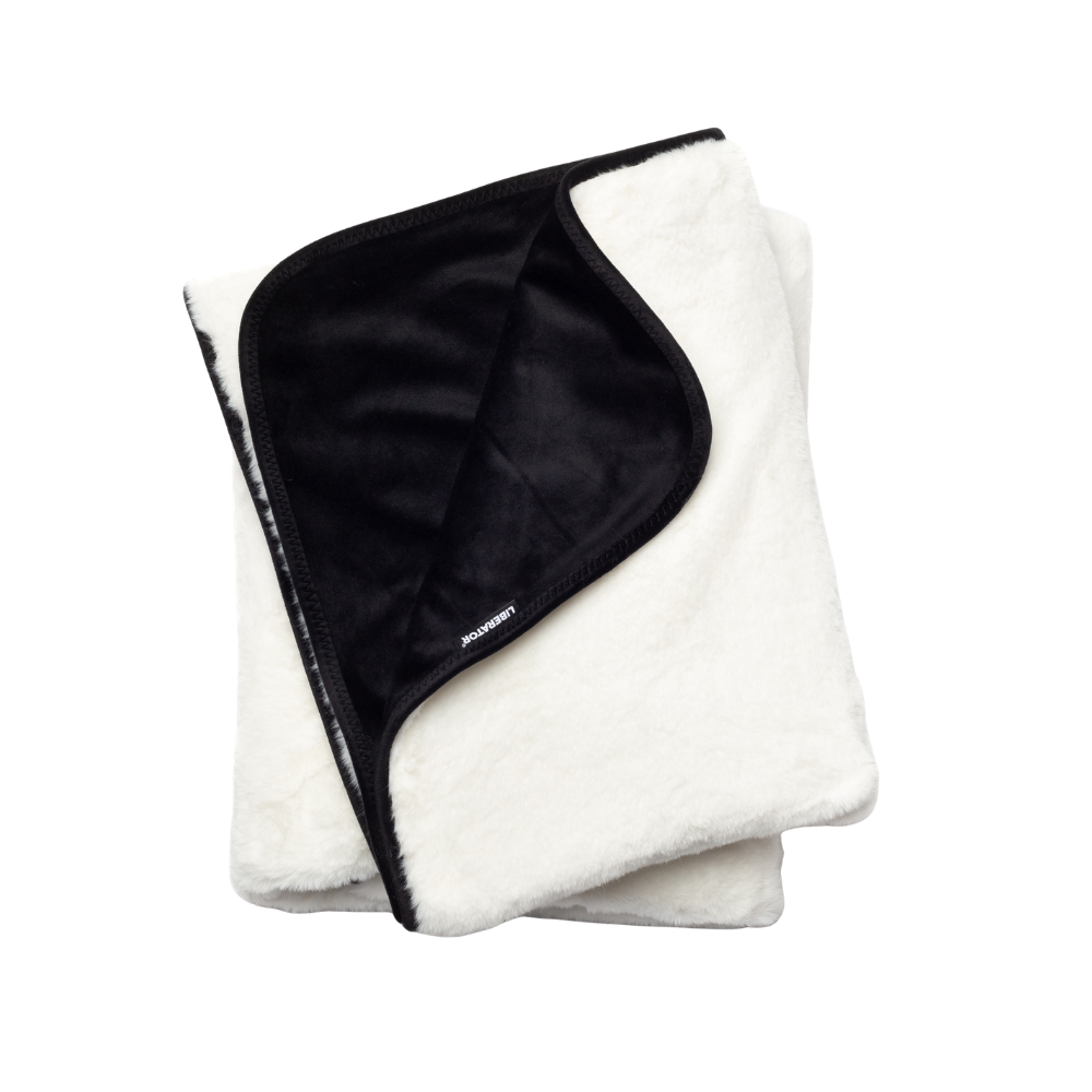 A white faux fur Fascinator Splashproof Throws, Bedroom Furniture by Liberator folded up.