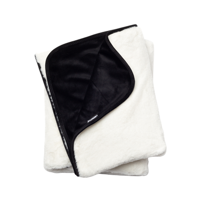 A white faux fur Fascinator Splashproof Throws, Bedroom Furniture by Liberator folded up.