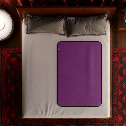 A travel size aubergine Fascinator Splashproof Throws, Bedroom Furniture by Liberator sitting on a bed.