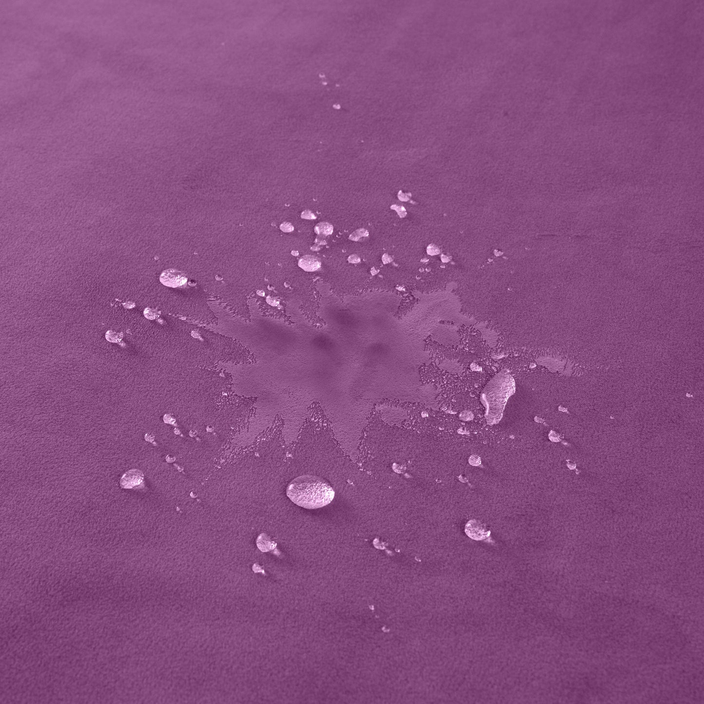 A purple Fascinator Splashproof Throws, Bedroom Furniture with water sitting on it showing it doesn't penetrate the blanket.