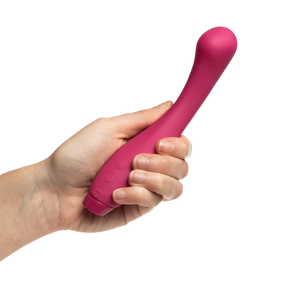 A hand holding a pink Juno vibrator by Je Joue.