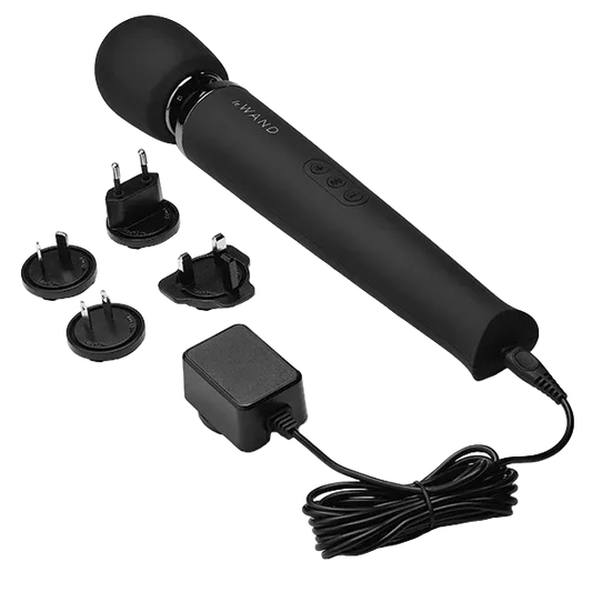 Black handheld Le Wand device with attachments and power adapter.