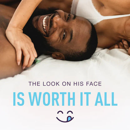 A man smiling and woman laying on a white sheet with the saying The Look on His Face Is Worth It All.