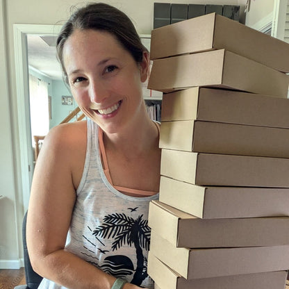 Nicole holding a pile of mystery ships boxes.