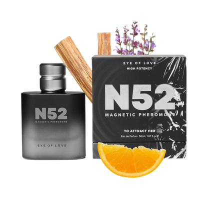 A black bottle of N52 Magnetic Pheromone Cologne by Eye of Love sitting next to the box, an orange slice and some lavender.