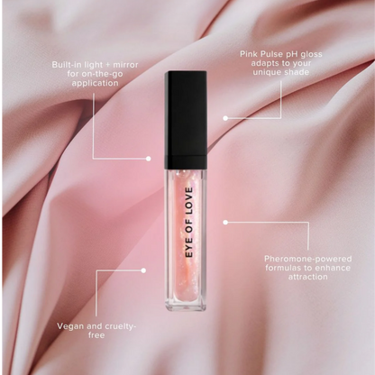 A pink tube of pH balanced Pink Pulse lip gloss by Eye of Love against a pink background with lines pointing out details of the gloss.