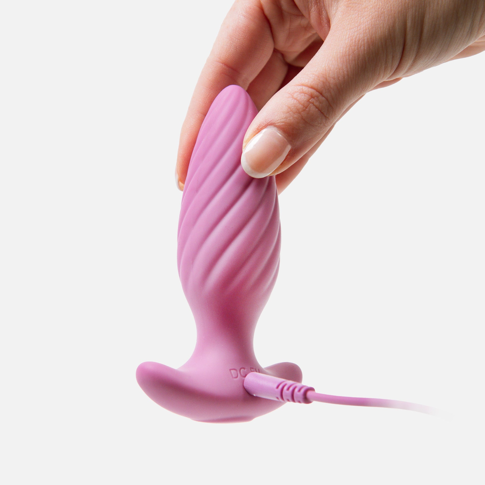 Pink silicone product with a cable held by a hand on a white background