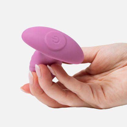Pink silicone plug held in a hand on a white background