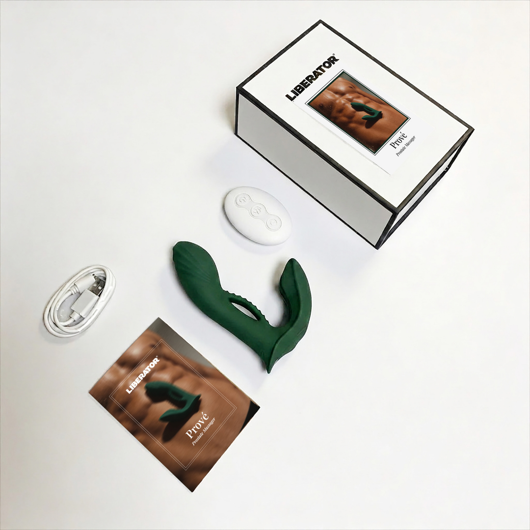 A green Prove Prostate Vibrator by Liberator with remote and charging cable laying beside the box.
