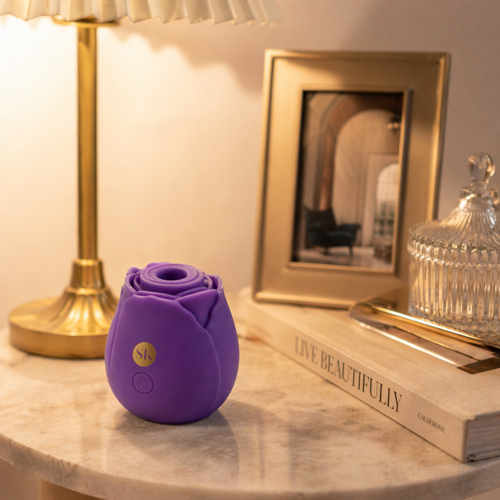 A purple Rosegasm Air Rose Clitoral Toy sitting on a side table.