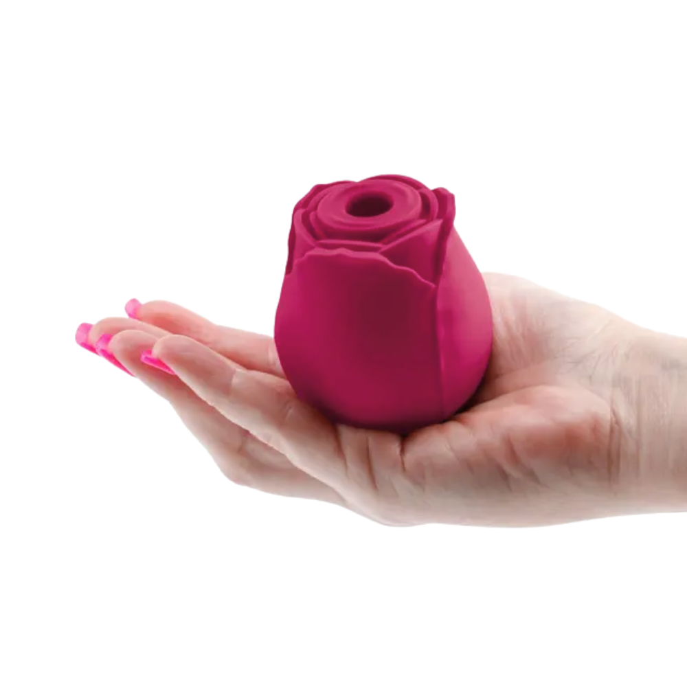A red Rosegasm Air Rose Clitoral Toy sitting on a hand.