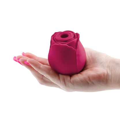A red Rosegasm Air Rose Clitoral Toy sitting on a hand.