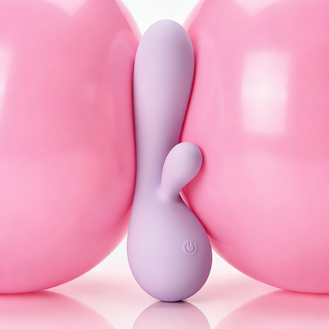 A pink Rya rabbit massager vibrator sitting between two pink balloons.
