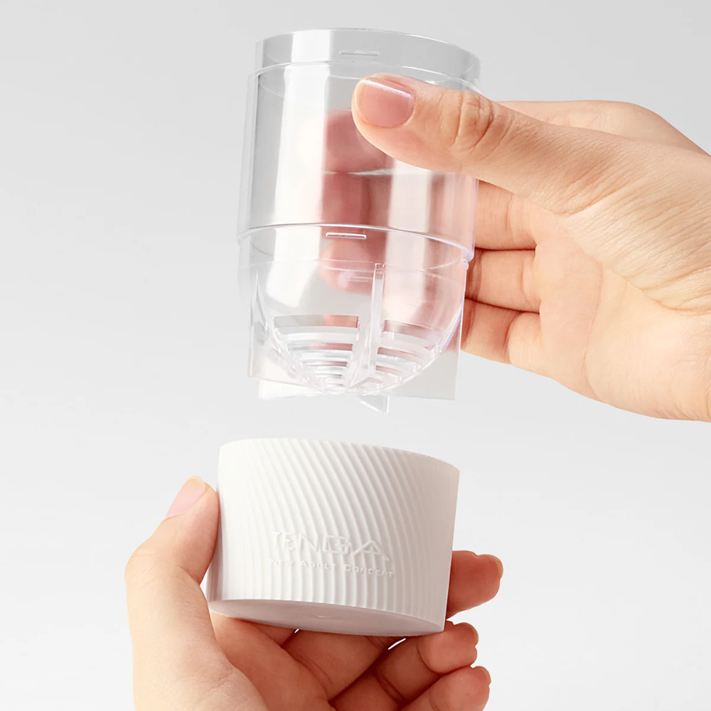 Hand holding a clear plastic container with a white base on a light gray background