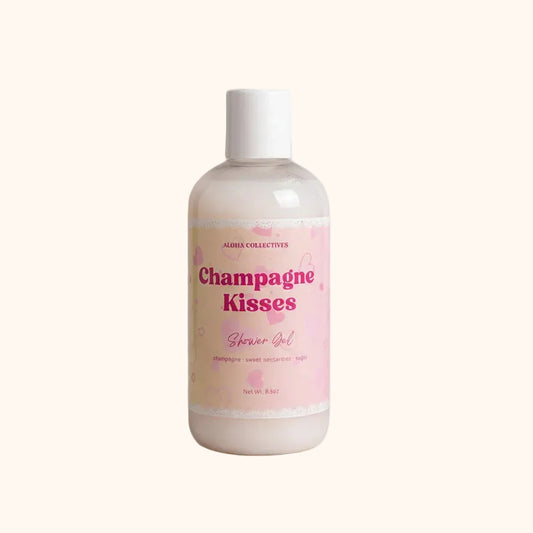 Bottle of 'Champagne Kisses' shower gel and bubble bath with a pink label on a beige background.