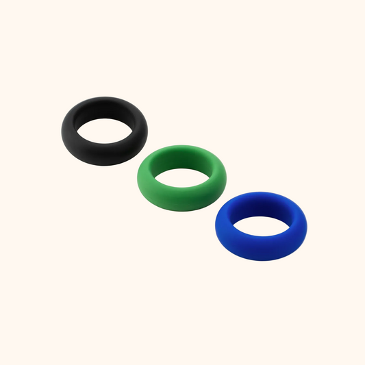 A Silicone Cock Ring Trio by Je Joue with a black, green and blue ring against a white background.