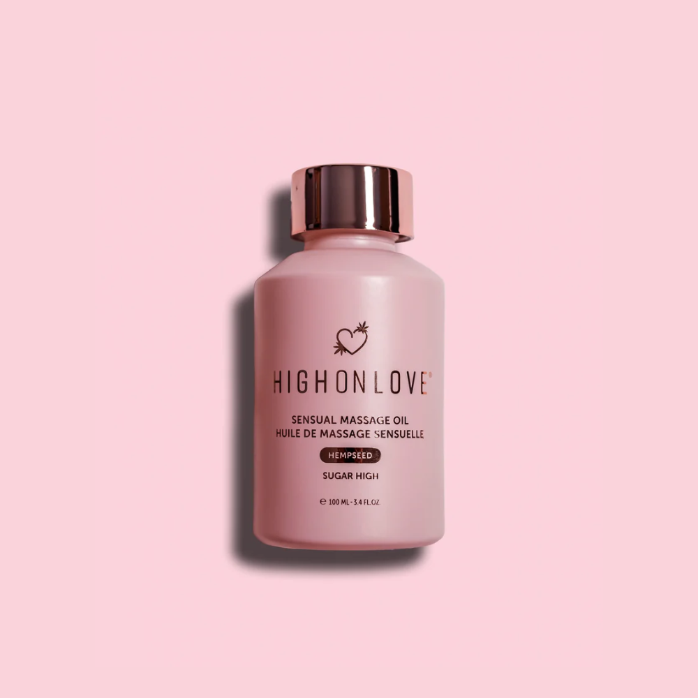 A pink bottle of Sugar High Massage Oil by High On Love against a pink background.