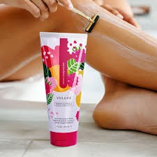 Vuluxe Shave Cream being shown by a woman shaving her legs.