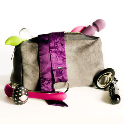 A grey Tallulah Locking Toy Bag by Liberator against a white background with toys coming out of it.