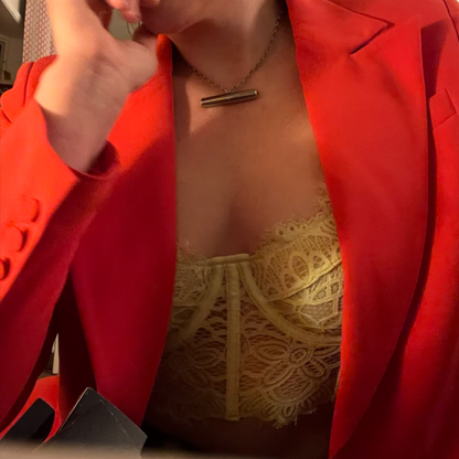 A lady wearing the 24k Gold Vibrator Necklace from the Tease Collection.