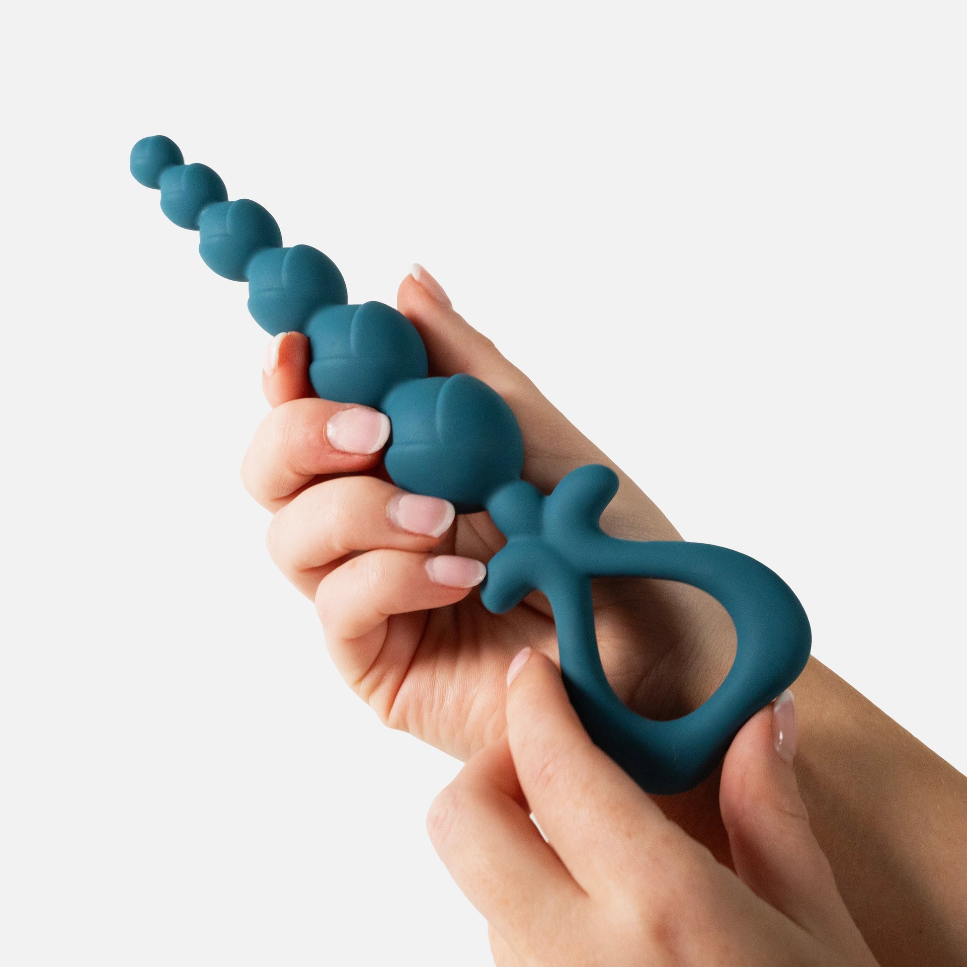 Teal silicone anal beads held by a hand on a white background