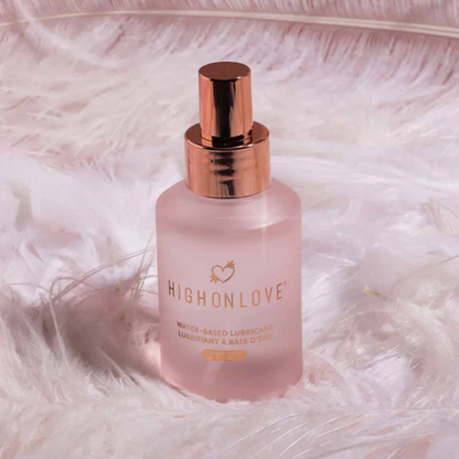 Pink bottle of High on Love water-based lubricant on a soft white background